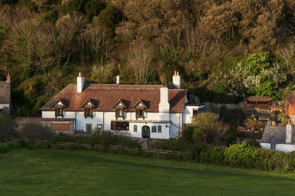 a white house with a brown roof at Lulworth Lodge in Lulworth Cove