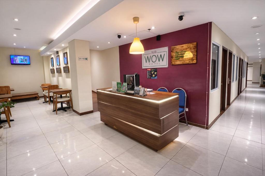 a lobby of a restaurant with a counter and tables at Subwow Hostel in Bandung