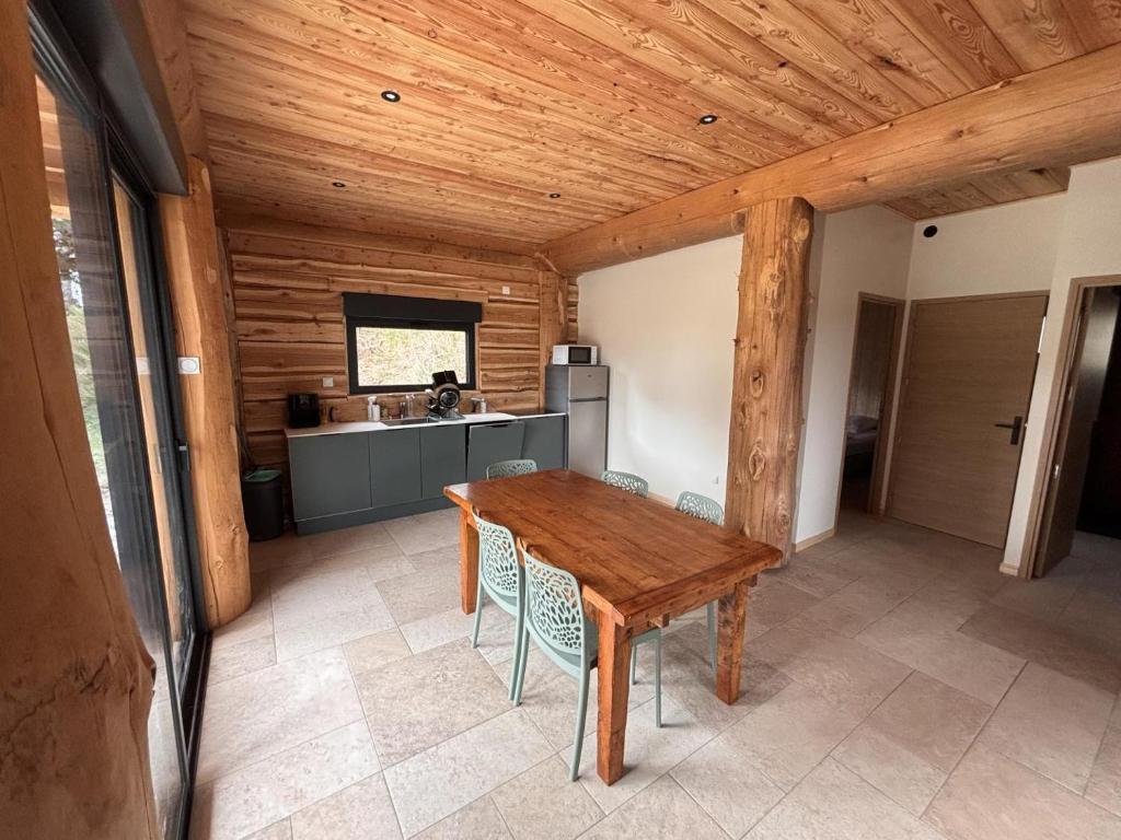a kitchen with a wooden table and chairs at L'ecorce sauvage 4/6 pers in Rocles