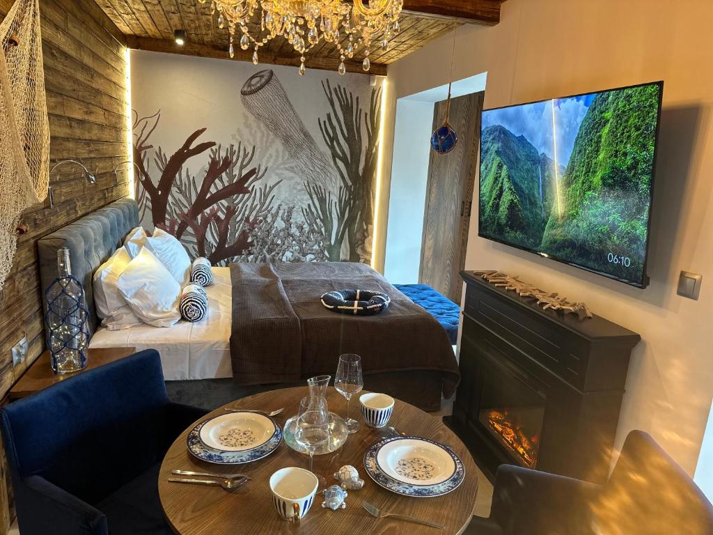 a room with a bed and a tv and a table at NOBILTON Dębki in Dębki