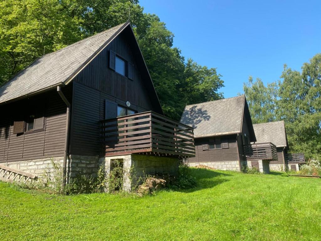 an old black barn on a green field at Chaty u Martiny in Nalžovice