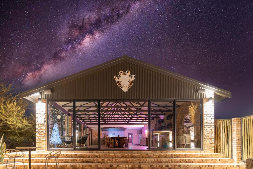 a building with a starry sky in the background at Windhoek Game Camp in Lafrenz Township