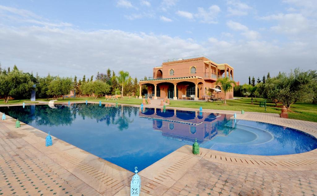 a house with a swimming pool in front of it at Villa privée, 5 suites, Piscine & Jardin XXL in Marrakesh