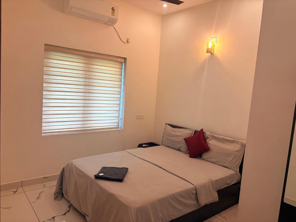 a small bedroom with a bed with a window at Zensta Residency in Cochin
