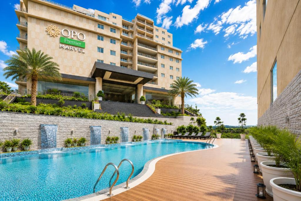 a hotel with a swimming pool in front of a building at OPO Premier Marvel in Jaipur