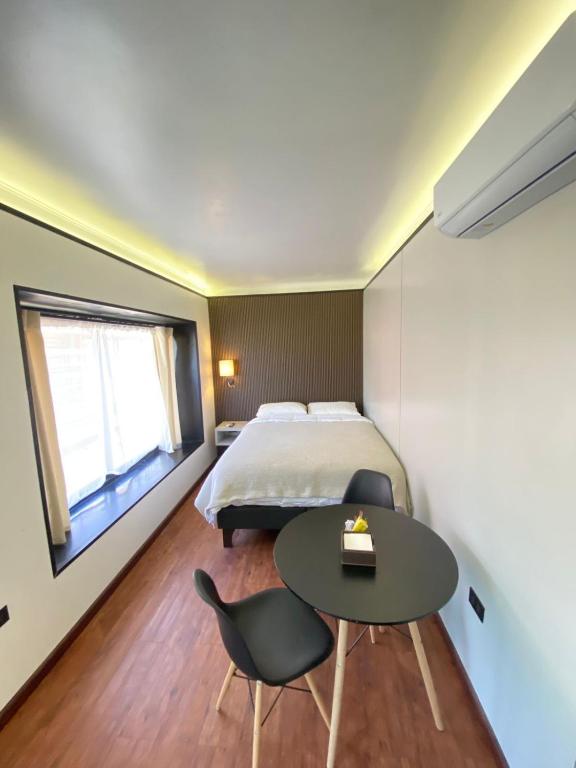 a bedroom with a bed and a table and chair at Cabaña San Pedro 2 in Concepción