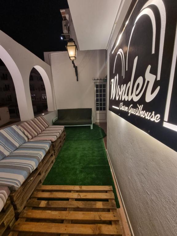 a room with a green carpet and a sign on the wall at Wonder Charm in Albufeira