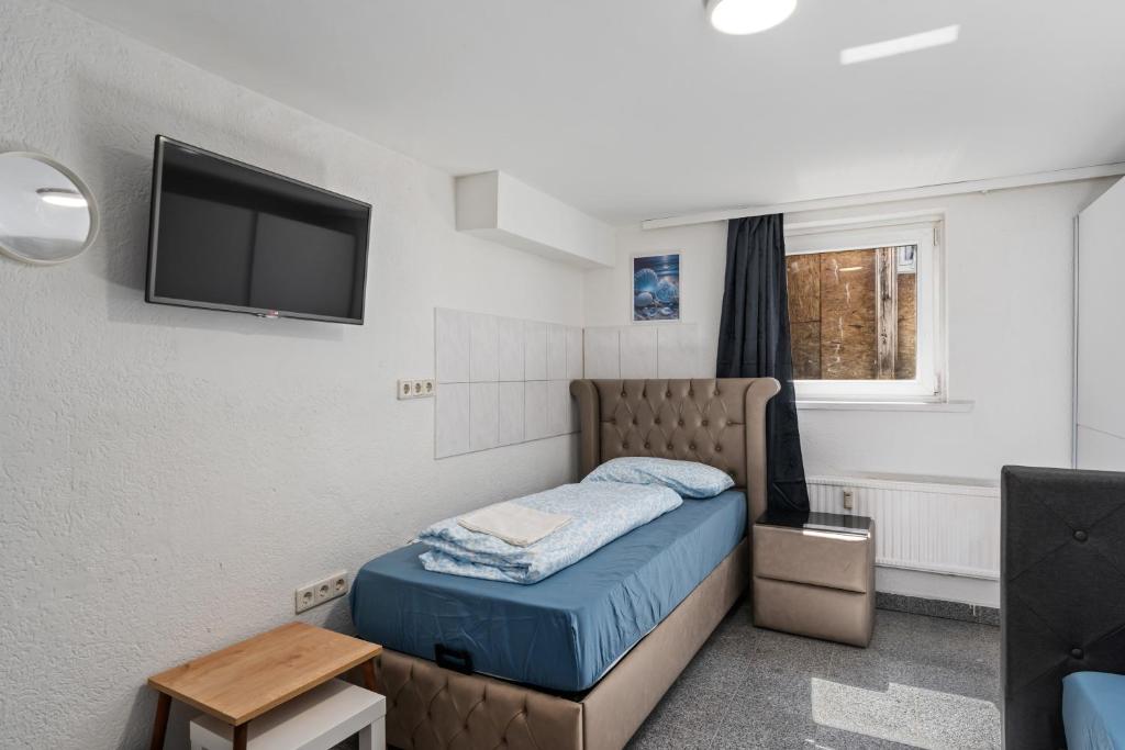 a small bedroom with a bed and a tv at MK Rooms Bremen in Bremen