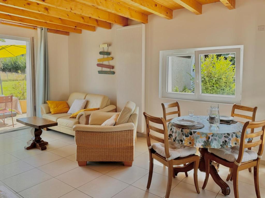 a living room with a table and chairs at Charmante maisonnette avec piscine partagée in Charancieu