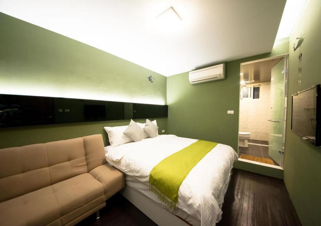 a bedroom with a bed and a couch at 羅東簡單住一晚 in Luodong