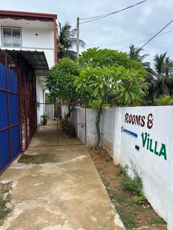 a house with a sign that reads rooms and villas at Ocean Heart Guest House in Nilaveli