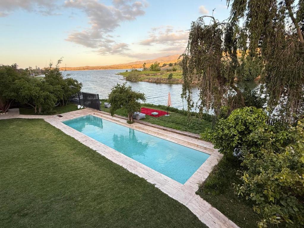 an overhead view of a swimming pool next to a river at Villa bord du lac takerkoust marrakech , 9 Suites de Luxe & événementiel in Wawizelt