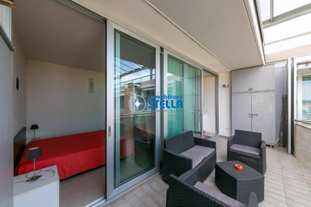 a room with a bed and a couch and a chair at Condominio Mimose in Eraclea Mare