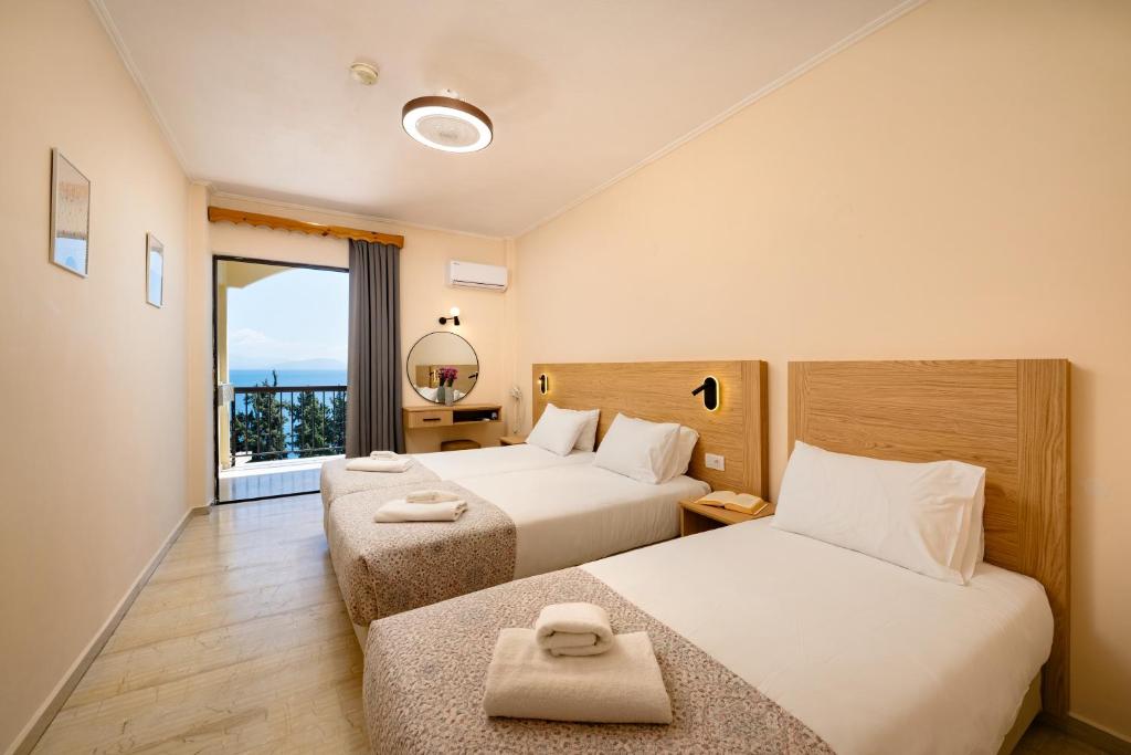 a hotel room with two beds and a window at Siora Leni Hotel in Benitses