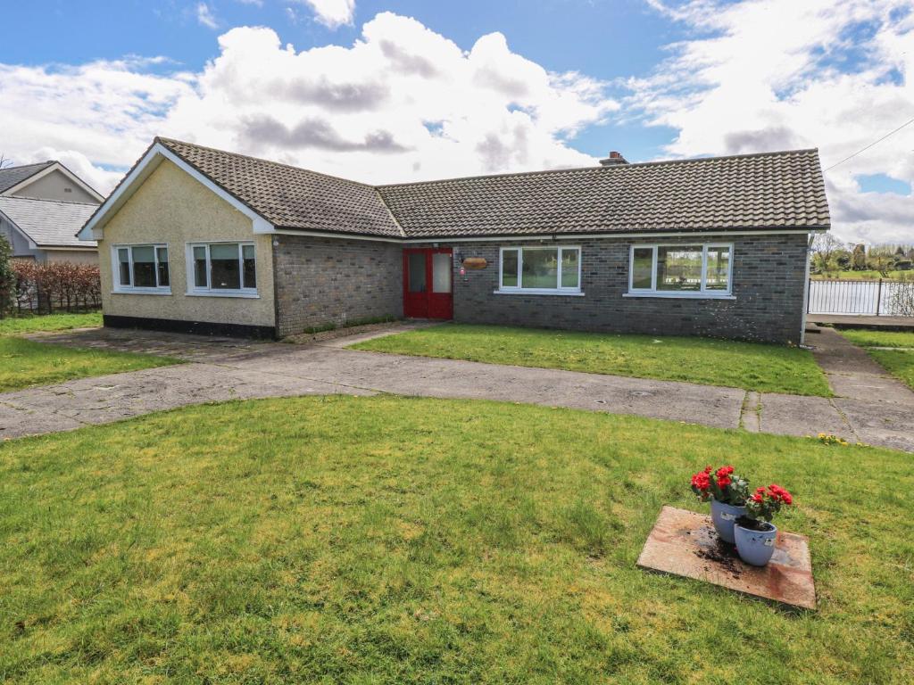 a house with a red door and a yard at Sweetbriar Lodge in Castlerea