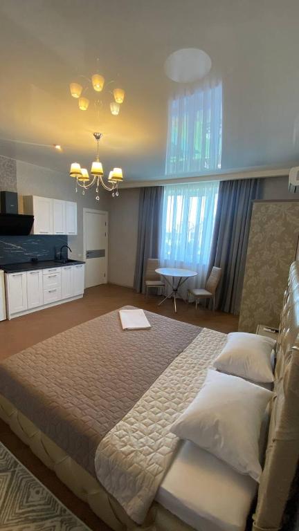 a large bedroom with a large bed and a kitchen at DiAmel in Petropavlovskaya Borshchagovka
