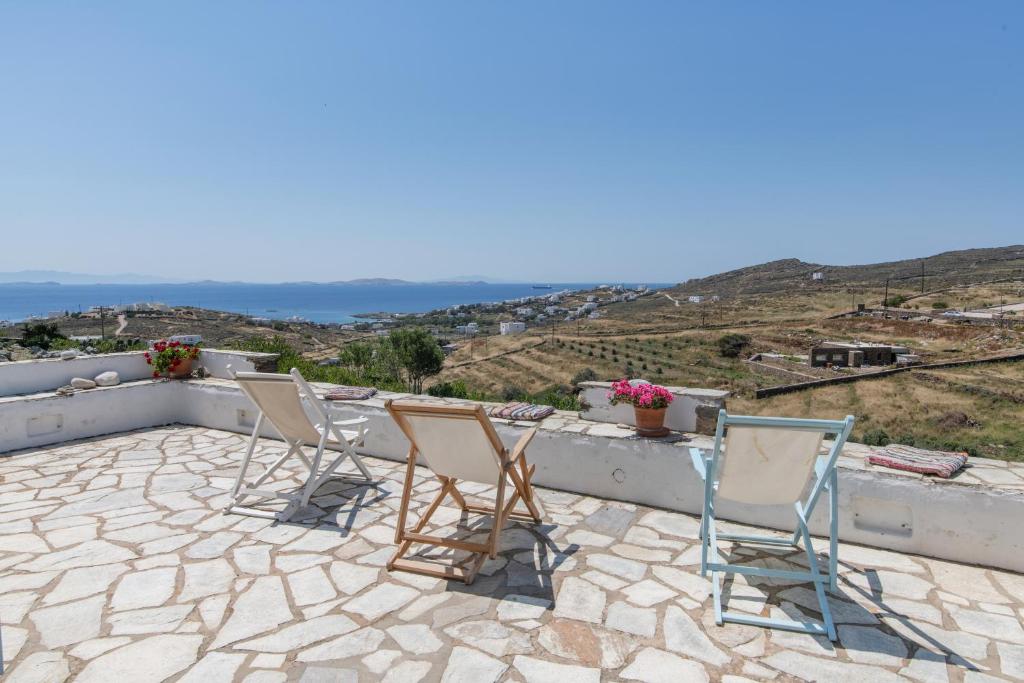 a group of chairs sitting on a patio with a view at Αστραία - με θέα στο Αιγαίο in Agios Ioannis