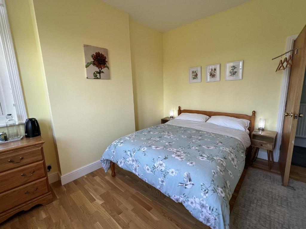 a bedroom with a bed with a blue bedspread at Swan Lodge in Swanage