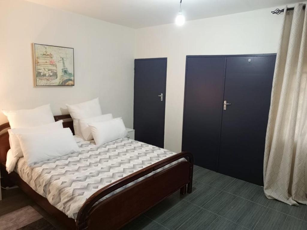 a bedroom with a large bed with black cabinets at Apartment 8, 7373A, Mtedza Rd in Lusaka