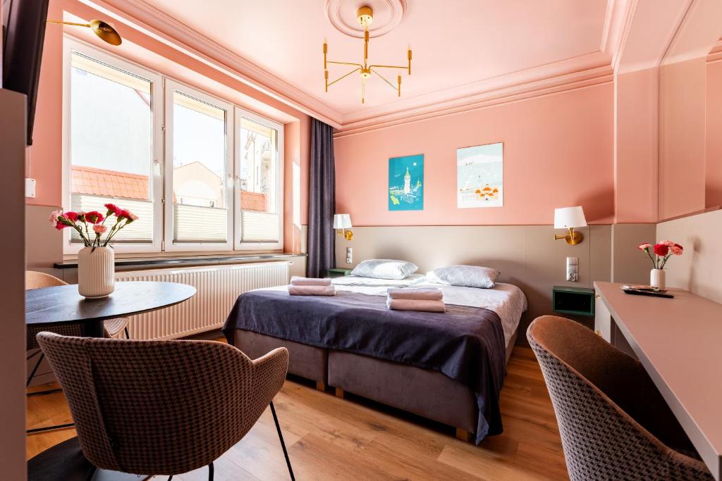 a hotel room with a bed and a table and chairs at Gościniec in Sopot
