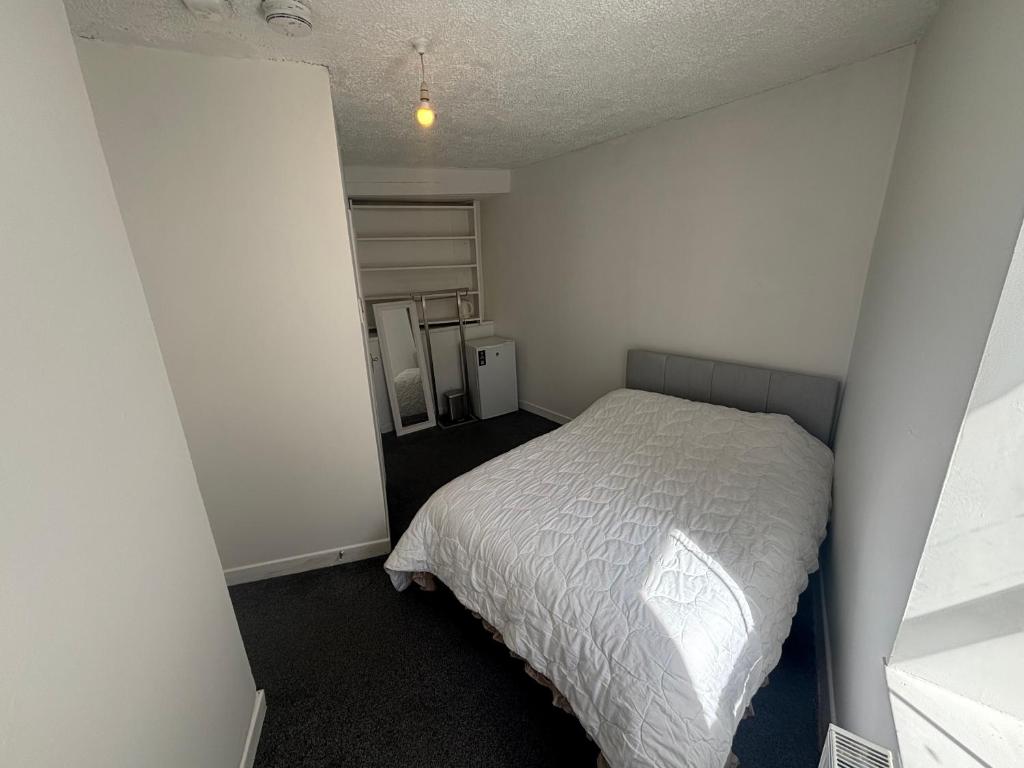 a bedroom with a bed in a white room at Kinsale central 5 in Kinsale
