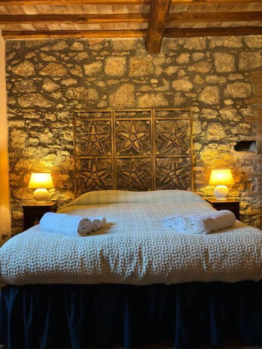 a bedroom with a large bed with towels on it at Fiorire Casale Olistico in Attigliano