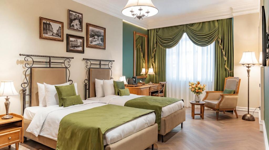 a hotel room with two beds and a desk at Hayasa Hotel Old Yerevan in Yerevan