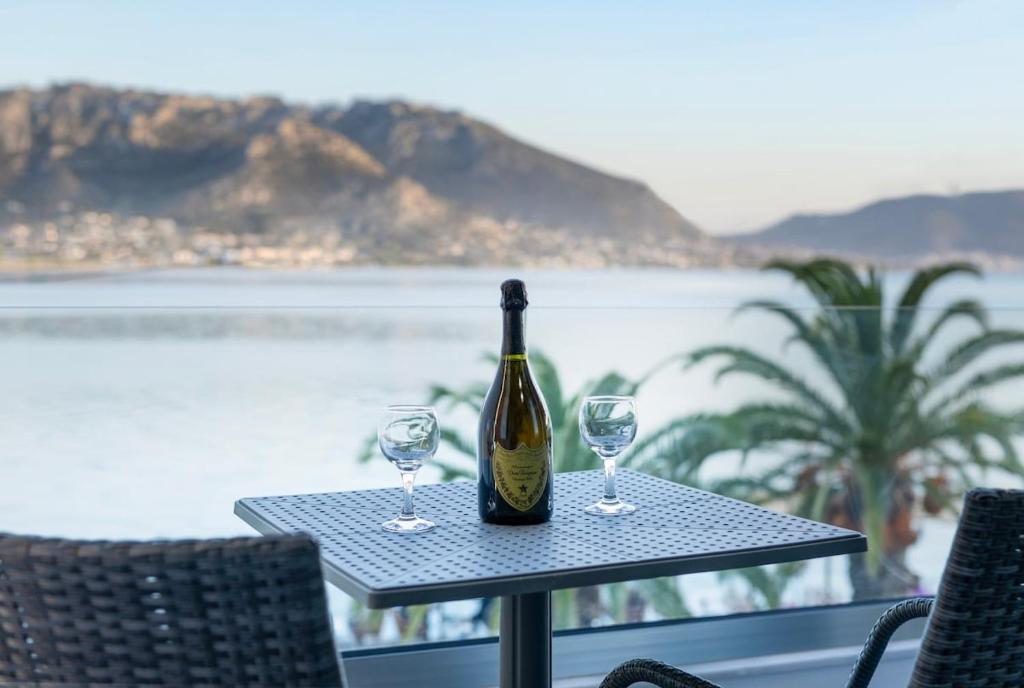 a bottle of wine sitting on a table with two glasses at Sea Breeze Stay 2 in Salamina
