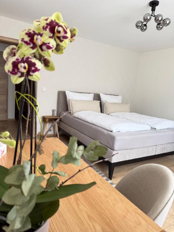 a living room with a couch and a table with flowers at Fewo-Welz in Bad Kissingen