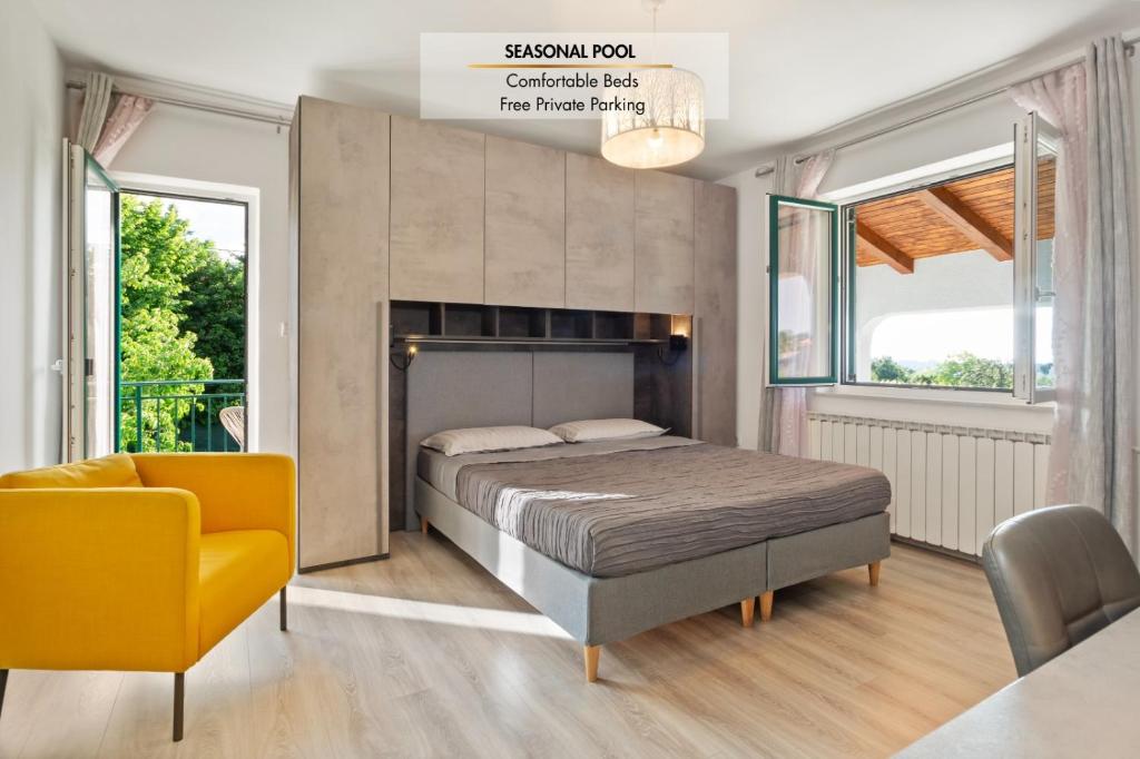 a bedroom with a bed and a yellow chair at NAT Apartments in Koper
