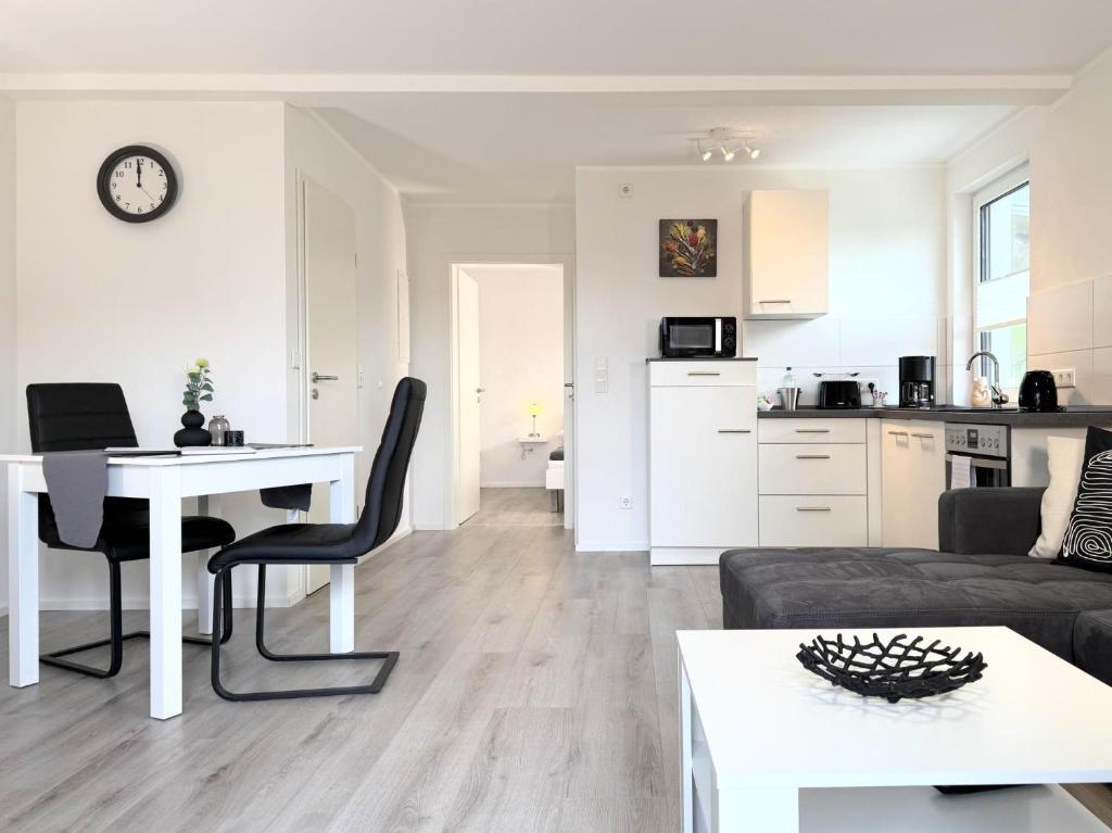 a white living room with a table and a kitchen at Fewo Diemelsee 4 in Heringhausen