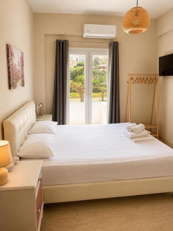 a bedroom with a large bed and a window at IOKASTI STUDIOS 5 in Andros