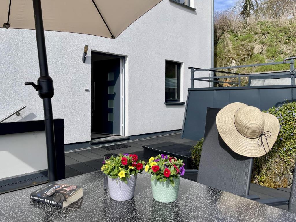 a hat sitting on a table with flowers on a patio at Fewo Diemelsee 2 in Heringhausen