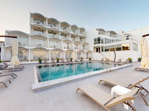 a large hotel with a swimming pool and chairs at Casa Mare Bodrum in Bodrum City
