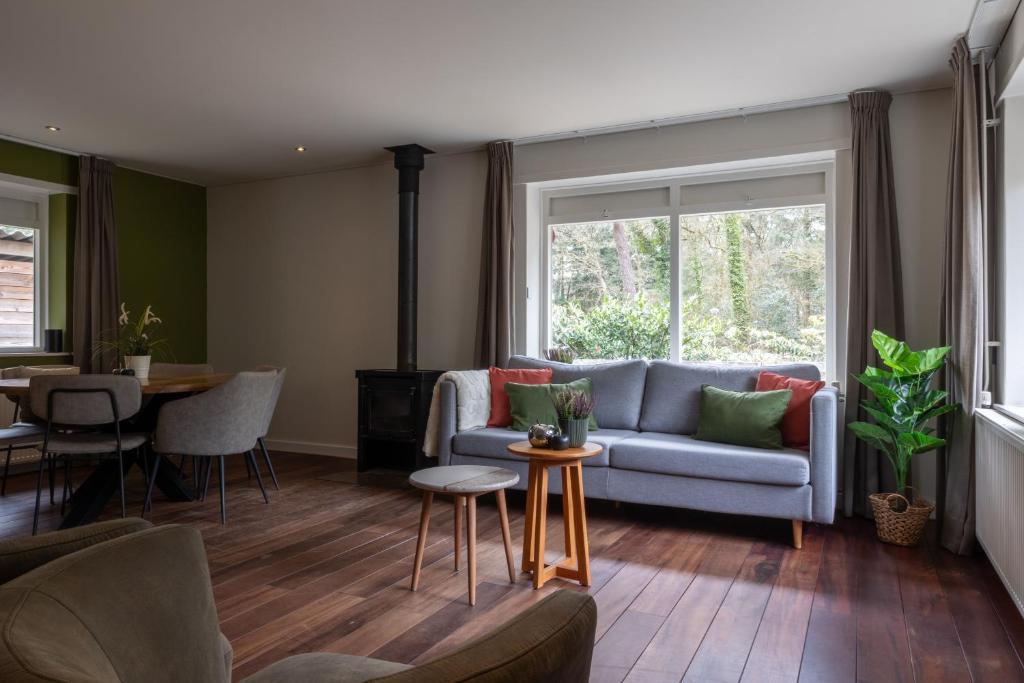 a living room with a couch and a table at De Bosberg Villa in Appelscha