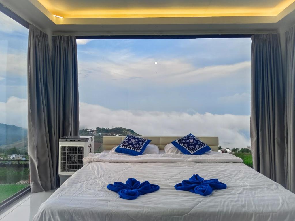 a bed in a room with a large window at วิวดีภูทับเบิก in Ban Maeo Thap Boek