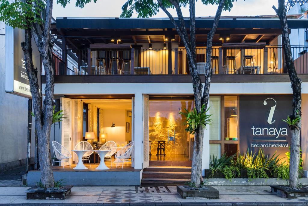 a building with tables and chairs in front of it at Tanaya Bed & Breakfast in Legian