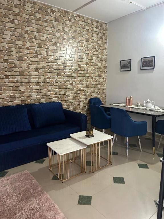 a living room with a blue couch and a table at Camellia The Bungalow in Dibrugarh