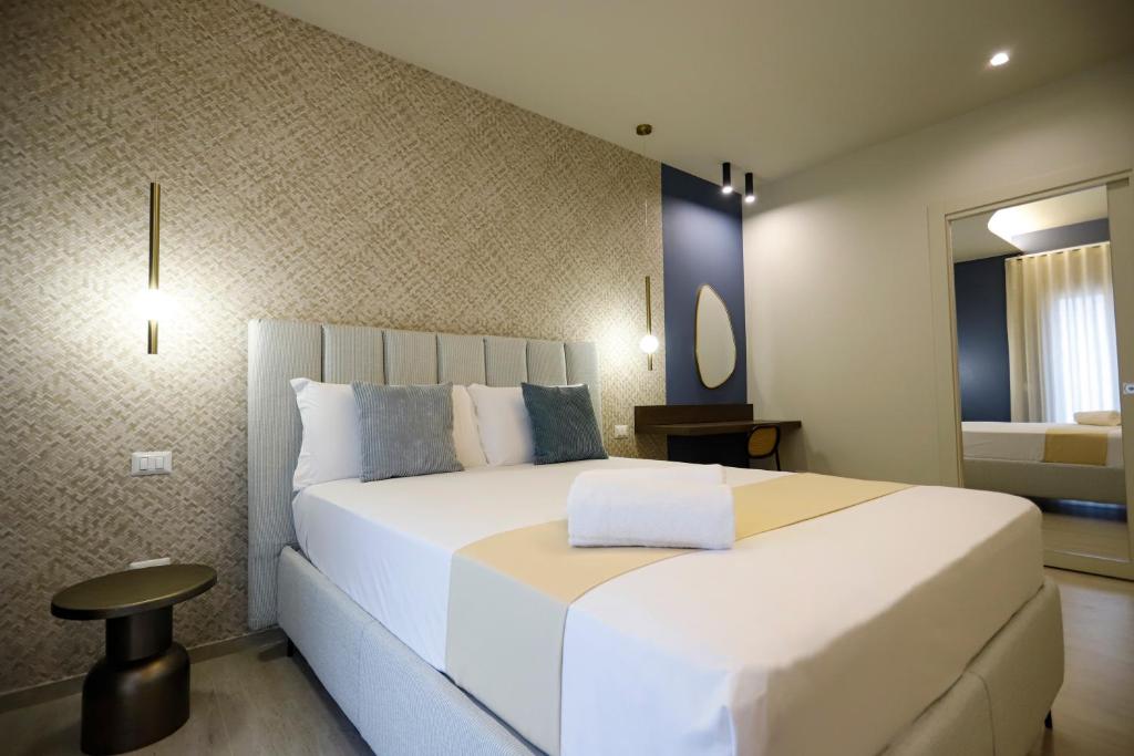 a bedroom with a large white bed in a room at Seõra Luxury Rooms in Porto Empedocle