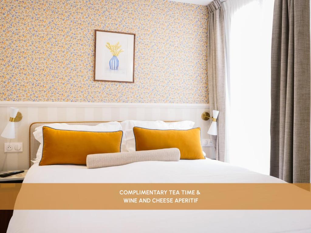 a bedroom with a bed with orange pillows at Joli Môme in Paris