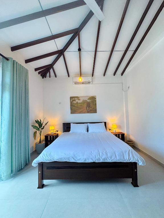 a bedroom with a large bed with two night stands at Slow Life Coliving, Hiriketiya in Dickwella