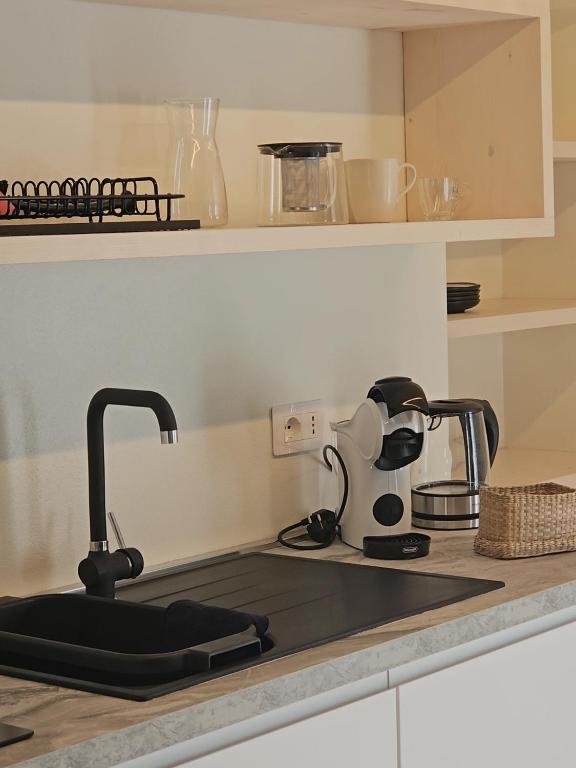 a kitchen counter with a sink with a coffee maker at La Cereria MARIA in Chiavenna