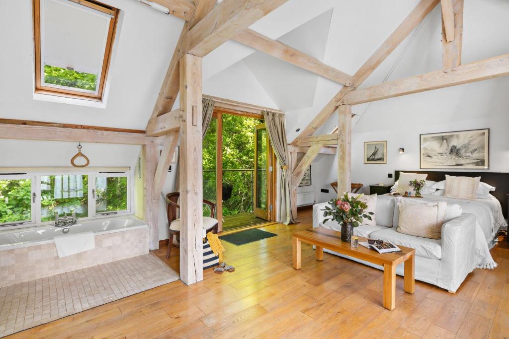 a living room with a bed and a bath tub at Barberry Brook - Swimming pool acces in Dittisham
