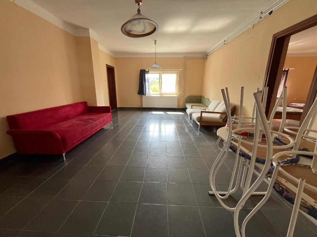 a living room with a red couch and chairs at Napsugár Apartman in Szaknyér