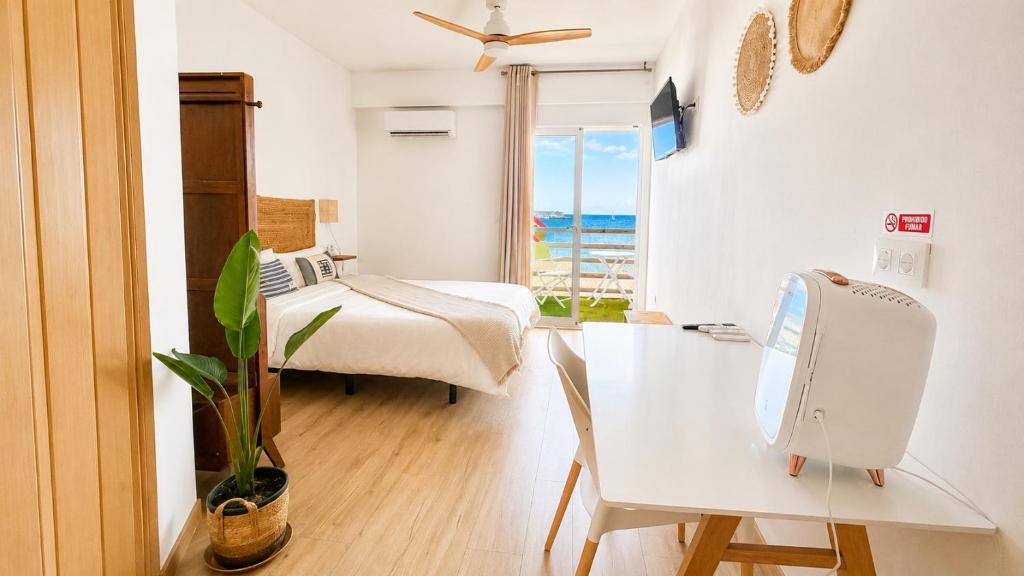 a bedroom with a bed and a desk and a table at Hostal playa Dreams náutico Adults in Garrucha