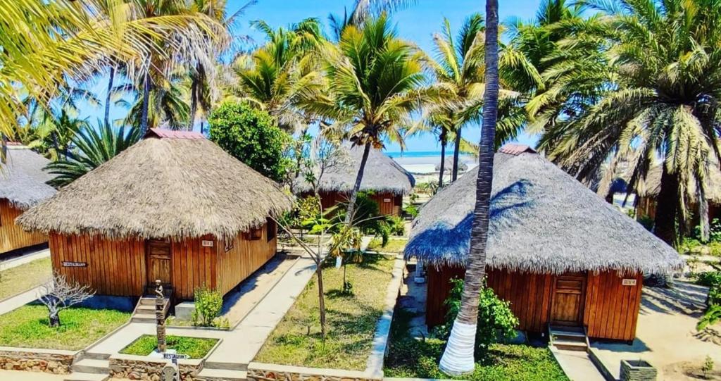 a resort with two huts and palm trees at Le Renala Morondava in Morondava