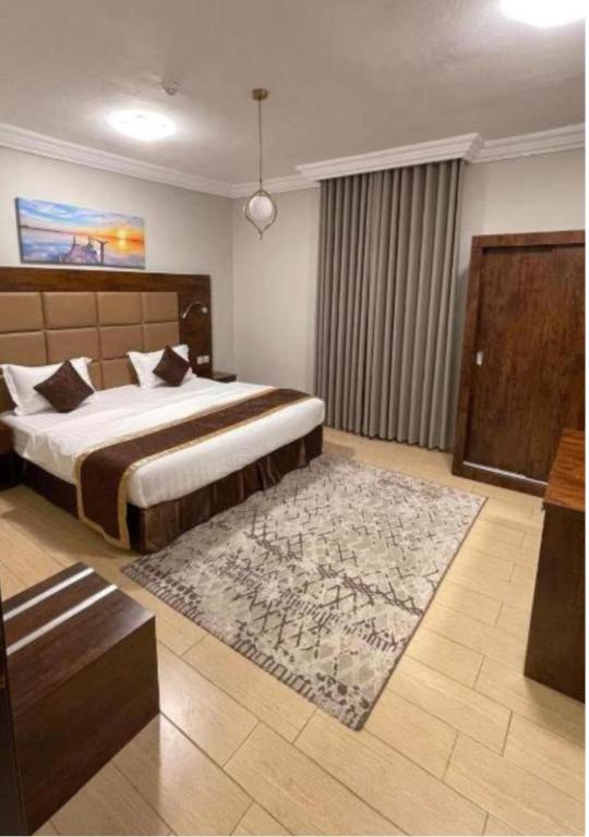 a bedroom with a large bed and a rug at فندق فاتوران فرع ينبع in Yanbu