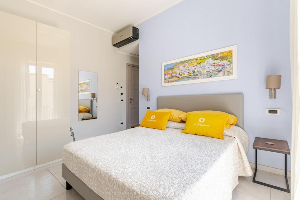 a white bedroom with a bed with yellow pillows at B&B La Piazzetta in Ischia Town