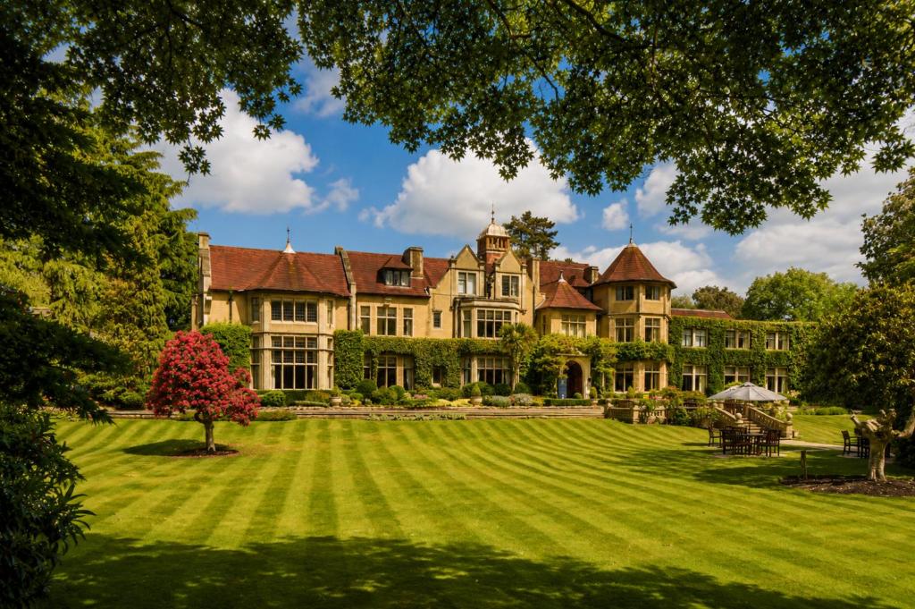 a large house with a large lawn in front at Macdonald Frimley Hall Hotel & Spa in Camberley