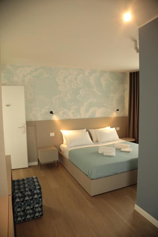 a bedroom with a bed with a painting on the wall at TAU Rooms Srl in Tricesimo